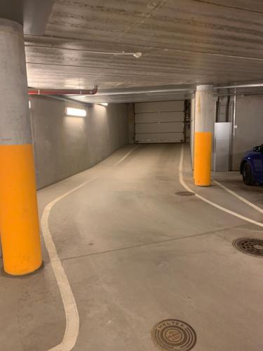 an empty parking garage with orange columns and a car at 2room Kalasatama Helsinki in Helsinki