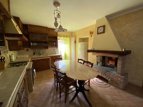 a kitchen with a wooden table and a fireplace at Pacentro Dimora del Castello in Pacentro