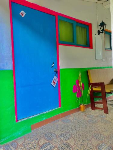 a large blue door in a room with a table at Hotel Marrokos Aeropuerto José María Córdova in Rionegro