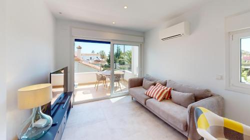 a living room with a couch and a tv at Sunrise by ON Travel in Oliva
