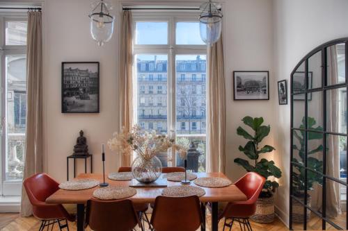 une salle à manger avec une table et des chaises et une grande fenêtre dans l'établissement Chic et décontracté centre de paris, à Paris