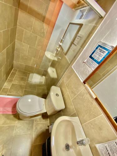 a bathroom with a toilet and a sink at Hotel Marrokos Aeropuerto José María Córdova in Rionegro