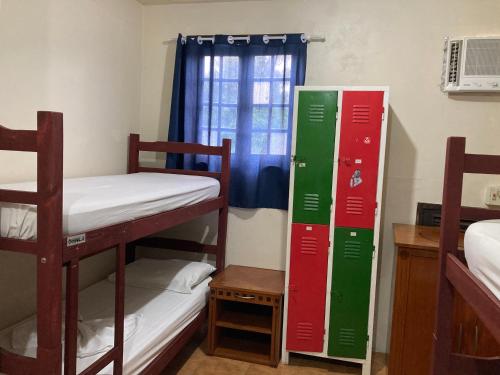 a room with three bunk beds and a window at Hostel e Pousada Barra da Tijuca in Rio de Janeiro