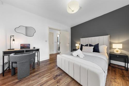 a bedroom with a white bed and a desk and a chair at Modern 2 Bedroom Apartment in Uxbridge London free parking in London