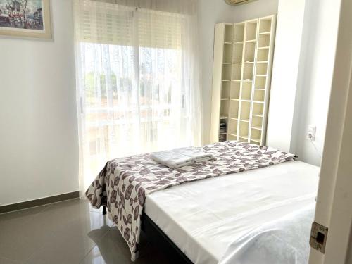 een bed in een kamer met een raam bij Dúplex Jardines de Denia I in Denia