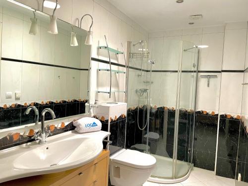 een badkamer met een douche, een toilet en een wastafel bij Dúplex Jardines de Denia I in Denia