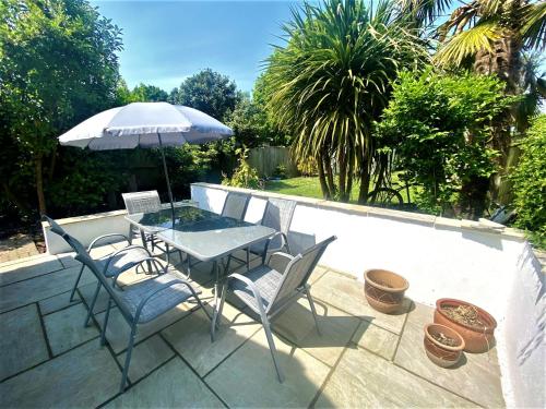 a table and chairs with an umbrella on a patio at Spacious home near the Marinas with ample parking in Lymington