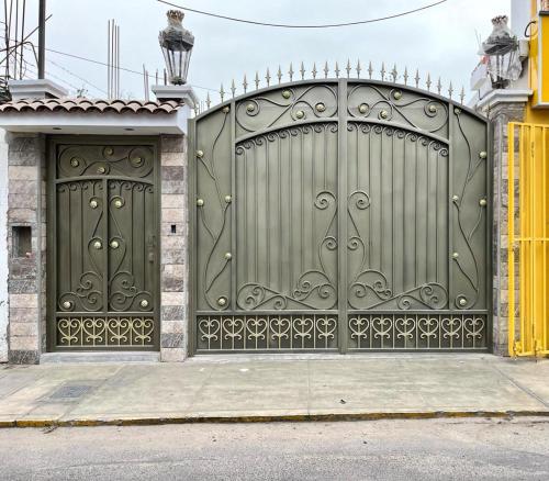a pair of gates on a house at El Huerto Hostel in Ica