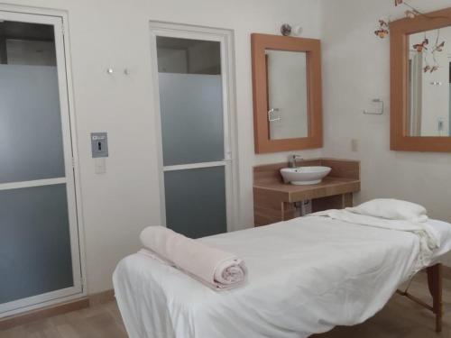 a white room with a bed and a sink at Centenario Los Arroyitos in Bernal