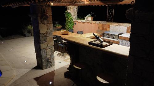 une cuisine extérieure avec un comptoir et une cuisinière dans l'établissement U Caseddu Di Francescu, piscine privée, plage à 10mins, à Figari