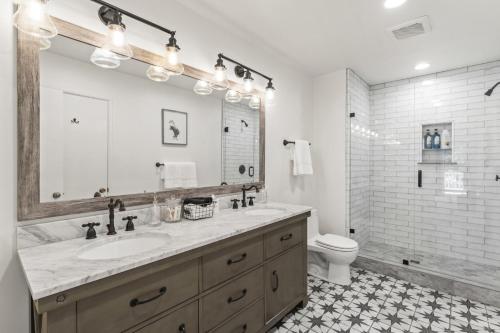 a bathroom with a sink and a toilet and a mirror at Luxe Mountain Retreat Lake Village Close Game Room AC Backs up to trails in Lake Arrowhead