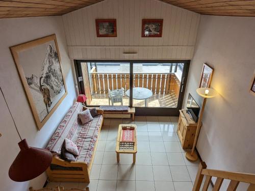 d'un salon avec un canapé et un balcon. dans l'établissement Duplex au centre de La Clusaz, balcon sud, proche pistes et commerces - FR-1-459-119, à La Clusaz