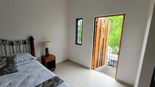 ein Schlafzimmer mit einem Bett und einer offenen Tür in der Unterkunft Casa Cecilia in Cozumel