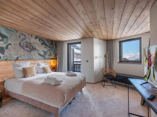 une chambre avec un grand lit avec un plafond en bois dans l'établissement Duplex Neuf Ski In/Out avec Spa et Piscine à Courchevel 1850 - FR-1-564-99, à Courchevel