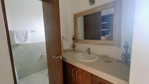 ein Badezimmer mit Waschbecken und Spiegel in der Unterkunft Casa Cecilia in Cozumel