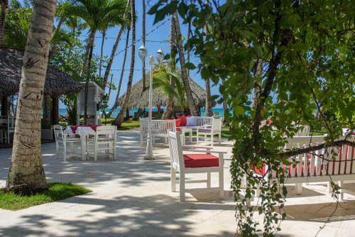 a row of white chairs and tables on the beach at Hotel Atlantis in Las Terrenas