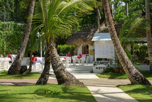 a group of palm trees in front of a building at Hotel Atlantis in Las Terrenas