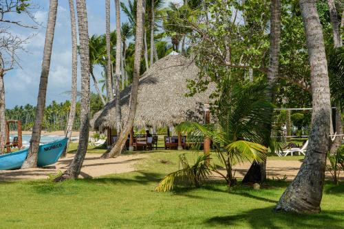 a resort with a straw hut and palm trees at Hotel Atlantis in Las Terrenas