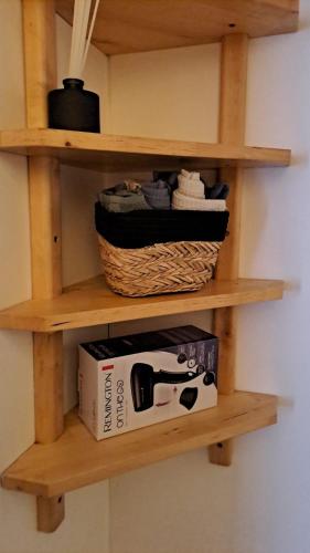 a shelf with a basket and a box on it at George&K Apartament in Larvik