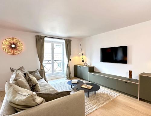 un salon avec un canapé et une télévision dans l'établissement Spacious Luxembourg Garden Family Flat, à Paris