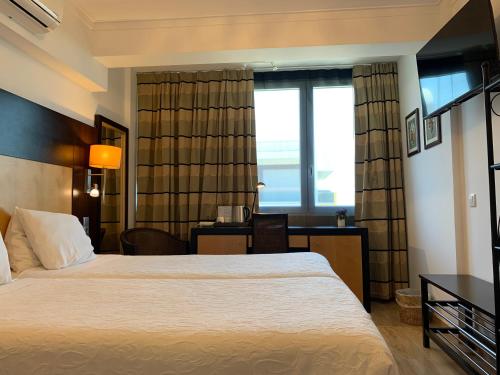 a hotel room with a large bed and a desk at Discovery Apartment Carnaxide in Carnaxide