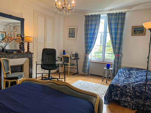 une chambre avec un lit, un bureau et une chaise dans l'établissement Refuge Raffiné - 2 Salons, Double Jacuzzi, Jardin, à Chatou