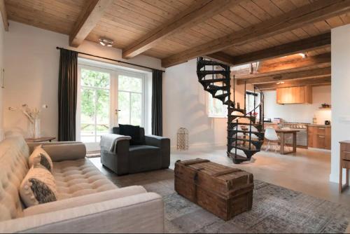 a living room with a couch and a spiral staircase at Beautiful House in The Middle of Nature in Abcoude