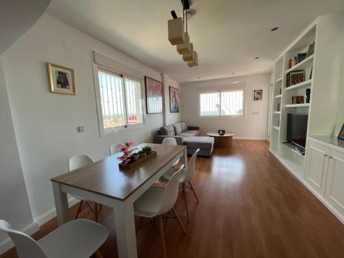 a dining room and living room with a table and chairs at Chalet con piscina privada y aacc in Peñíscola