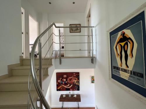 a staircase in a house with a poster on the wall at Chalet con piscina privada y aacc in Peñíscola