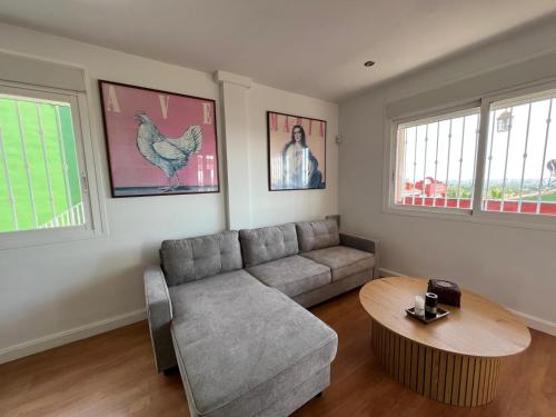 a living room with a couch and a table at Chalet con piscina privada y aacc in Peñíscola