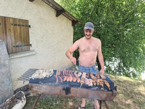 a man standing next to a barbecue grill at La Barkalo in Autet