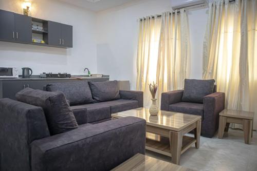 a living room with a couch and two chairs and a table at Opulence apartment in Karsana