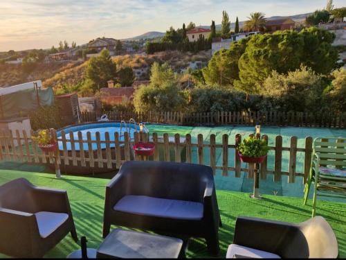 a backyard with a pool and chairs and a fence at Casita con piscina cerca de Chinchón, Aranjuez y Parque Warner in Colmenar de Oreja