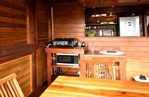 a kitchen with a table in a wooden cabin at Domaine de Ti Coin in Rivière-Salée