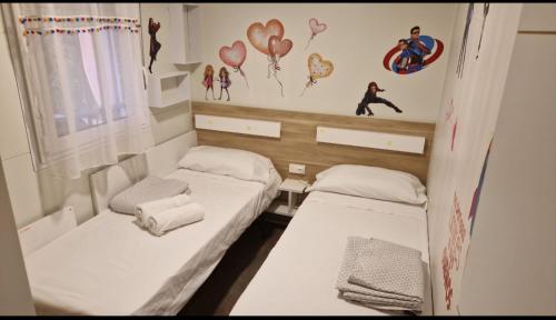 two beds in a small room with hearts on the wall at Casita con piscina cerca de Chinchón, Aranjuez y Parque Warner in Colmenar de Oreja