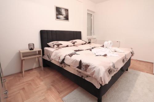 Un dormitorio con una cama grande con cabecero negro. en Golden Royal M, en Kragujevac