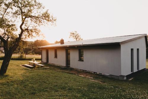 a white house with a picnic table in a yard at Śliwkowy Sad-Plum Orchard-Jura in Mirów