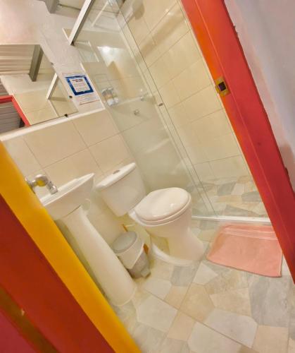 a bathroom with a toilet and a sink at Hotel Marrokos Aeropuerto José María Córdova in Rionegro