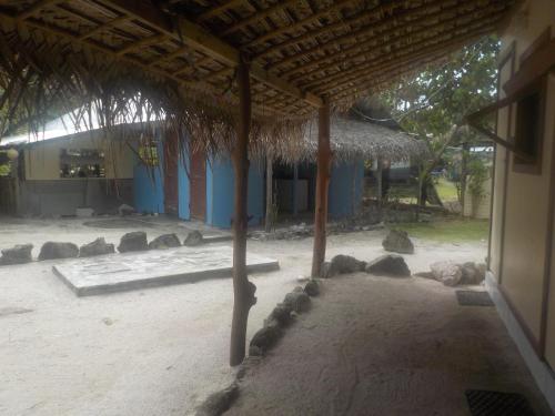 a building with a straw roof and some rocks at Camping Hiva Plage in Parea