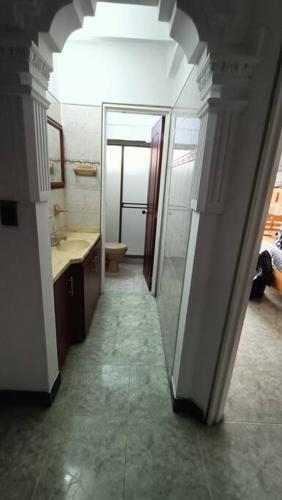 a hallway to a bathroom with a sink and a mirror at apartment in neiva goliat 102 in Neiva