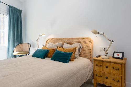 1 dormitorio con 1 cama con almohadas azules y naranjas en Torreguadiaro flat - 2 min to beach, en San Roque
