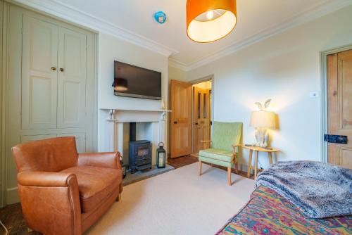 a bedroom with a bed and a chair and a fireplace at Castlehaw View in Sedbergh