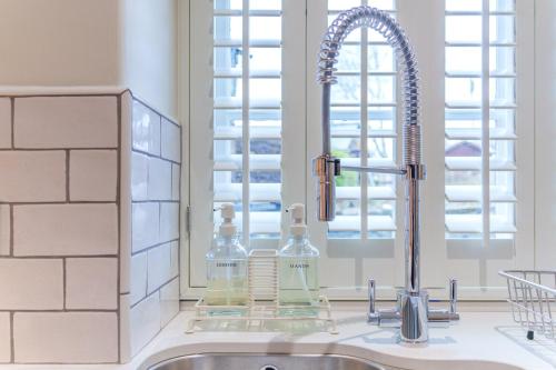 a kitchen sink with a faucet next to a window at Castlehaw View in Sedbergh