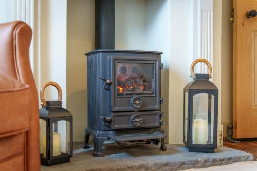 a blue stove in a room with two candles at Castlehaw View in Sedbergh