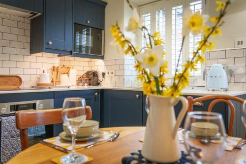 a kitchen with a table with a vase with yellow flowers at Castlehaw View in Sedbergh