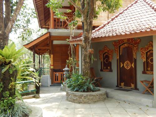 a house with a wooden door and a tree at Villa Dua Bintang in Munduk