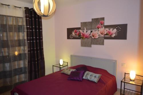 une chambre avec un lit rouge avec deux lampes et des fleurs sur le mur dans l'établissement Villa Mare e Machja, à Zonza