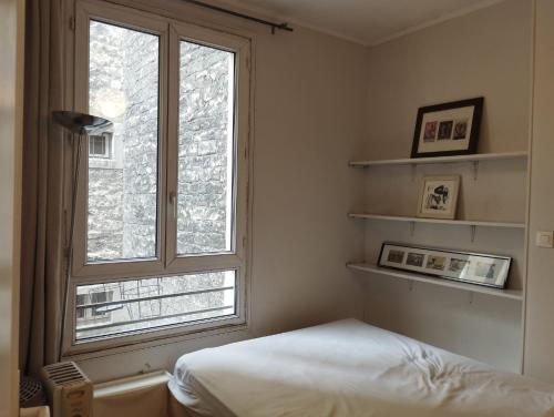 - une chambre avec une grande fenêtre et un lit dans l'établissement Cosy appartement next to Olympic sites, à Paris