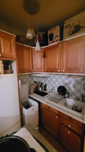 une cuisine avec des armoires en bois et un four à plaques de cuisson dans l'établissement Cosy appartement next to Olympic sites, à Paris