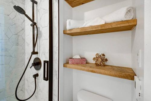 a bathroom with a shower with a toilet and a sink at Modern Cottage in the Tremblant Ski Village in Mont-Tremblant